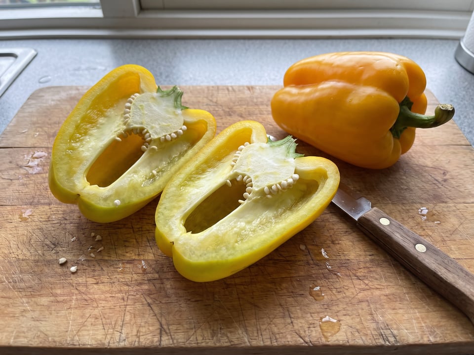 A Flavorburst pepper cut open lengthwise beside a whole pod, showing the wall and seed cavity